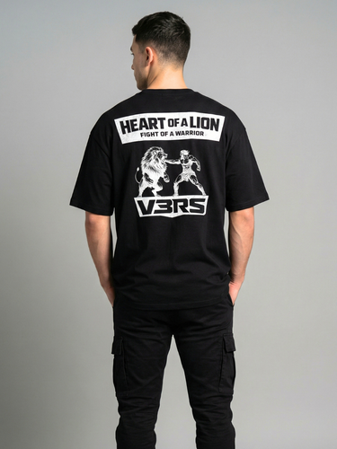 Person wearing a black t-shirt with 'Heart of a Lion' and 'Vers' branding on the back, standing against a gray background.
