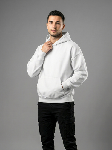 Man wearing a white hoodie and black pants on a gray background