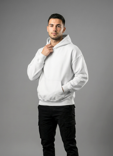 Man wearing a white hoodie and black pants on a gray background