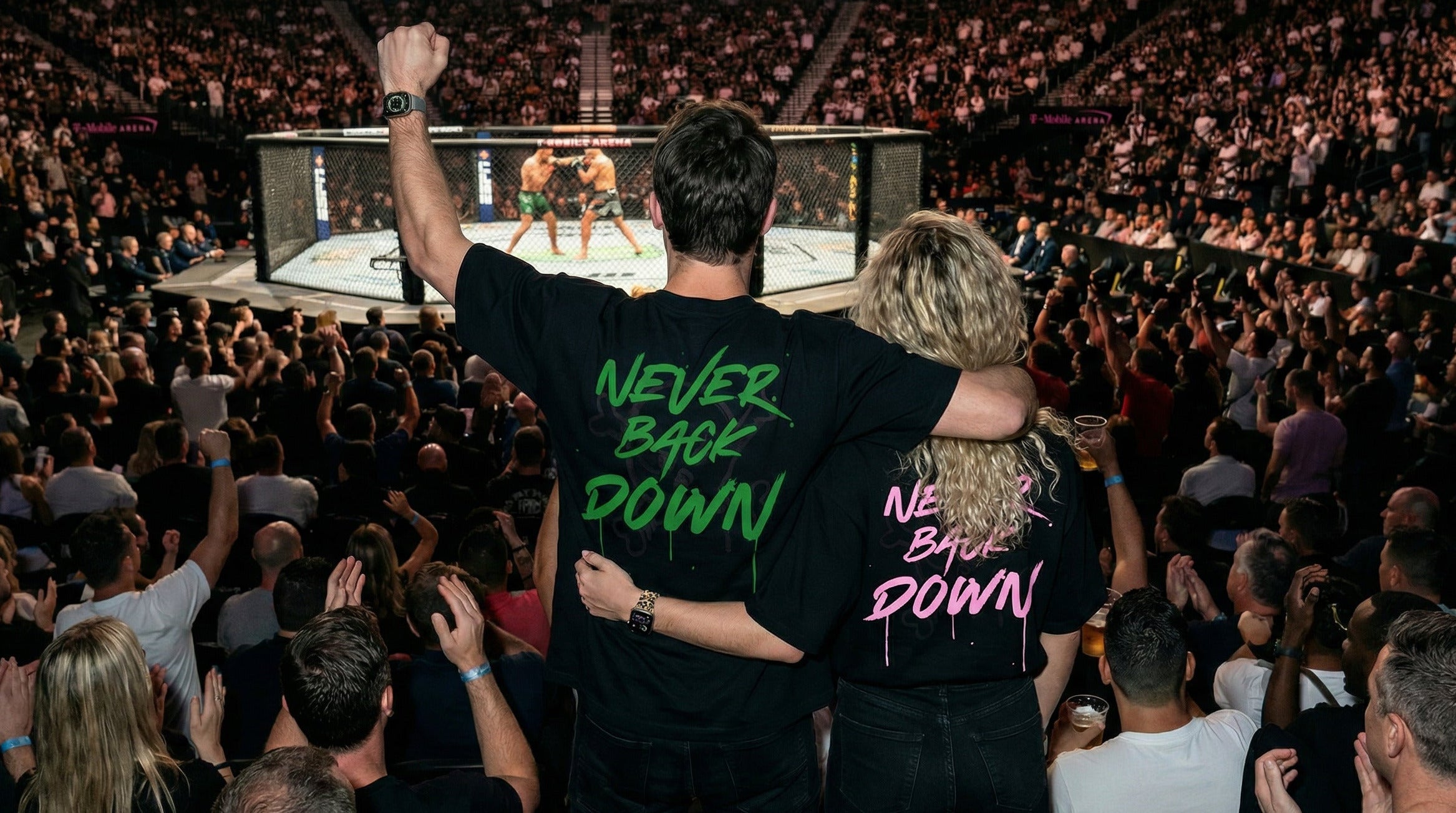 Two people in the crowd at a UFC event with 'Never Back Down' shirts.